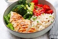 Delicious buddha bowl with grilled chicken, fresh vegetables and rice on a light background Royalty Free Stock Photo