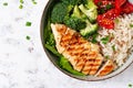 Delicious buddha bowl with grilled chicken, fresh vegetables and rice on a light background. Top view, above Royalty Free Stock Photo