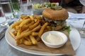 Delicious burger lunch with chips and dressing in city restaurant