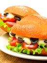 Delicious burgers with green salad, ham, tomatoes and olives Royalty Free Stock Photo