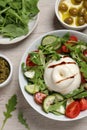 Delicious burrata salad served on wooden table, flat lay