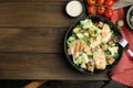 Delicious Caesar salad in bowl on wooden table, flat lay. Space for text Royalty Free Stock Photo