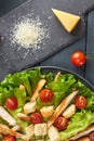 Delicious Caesar salad with cherry tomatoes and croutons and piece and grated parmesan cheese