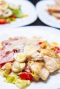 Delicious caesar salad with quail eggs,bacon strips,chicken meat,parmesan cheese served on white plate in Italian restaurant for Royalty Free Stock Photo