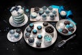 Delicious cake and cupcakes in blue on dark background. Table setting for celebration Royalty Free Stock Photo