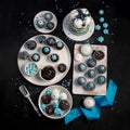Delicious cake and cupcakes in blue on dark background. Table setting for celebration Royalty Free Stock Photo