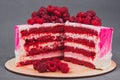 A delicious cake decorated with raspberries on a gray background.