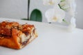 Delicious cake with peanut butter cream layer and chocolate topping. Bakery white magnolia flower on background. Selective focus