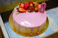 Delicious cake with pink stuff and fruits on top