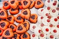 Delicious cakes in the form of hearts on a table for guests. Colorful sweets for special ocasion on a tray. Close-up.