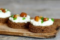 Delicious canape with soft cheese and mushrooms on a board on a wooden background Royalty Free Stock Photo