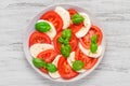 Delicious caprese salad with ripe tomatoes and mozzarella cheese with fresh basil leaves. Italian food Royalty Free Stock Photo