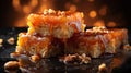 Delicious caramel cakes with nuts on black table against blurred lights, closeup