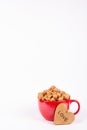 Delicious caramel popcorn in red mug and wooden heart. Romantic concept. Royalty Free Stock Photo