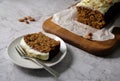 Delicious carrot cake with walnuts and almonds with icing cream on a light background.