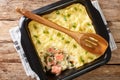 Delicious casserole with mashed potatoes, cream, onions and salmon close-up in a baking dish. horizontal top view