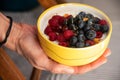 Delicious ceramic yellow bowl with fresh berries (raspberries and blackberries) and cereals Royalty Free Stock Photo