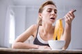 Cheerless young woman pretending to eat