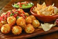 Delicious Cheese Stuffed Fried Jalapeno Balls with Salsa and Guacamole on Wooden Table