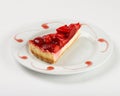 Delicious cheesecake with strawberry jelly and jam on the plate on white background. Royalty Free Stock Photo