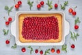 Delicious cherry pie with jelly in the baking dish on the gray kitchen background. Homemade cherry tart with fresh berries Royalty Free Stock Photo