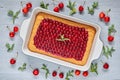 Delicious cherry pie with jelly on the gray kitchen background. Homemade cold cherry tart decorated with fresh berries and mint Royalty Free Stock Photo