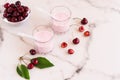 Delicious cherry smoothie in glass glasses on a marble table. bowl with fresh cherries Royalty Free Stock Photo