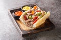 Delicious Chicago Italian beef sandwich with slow cooked beef and Giardanarra close-up on a wooden tray. horizontal