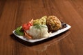 Delicious chicken cutlet breaded in breadcrumbs, with rice, French fries, tomatoes and cucumbers Royalty Free Stock Photo