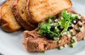 Delicious chicken, duck, or rabbit liver pate or foie gras with spices. fried toast and pate with microgreens