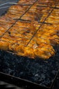 Delicious chicken frying on barbecue grill grate outdoor. Seasoning falling on fresh grilled chicken wings. Summer party Royalty Free Stock Photo