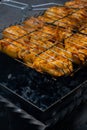 Delicious chicken frying on barbecue grill grate outdoor. Seasoning falling on fresh grilled chicken wings. Summer party Royalty Free Stock Photo