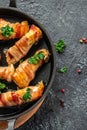 Delicious chicken rolls wrapped in strips of bacon on a cast-iron frying pan. Concept healthy and balanced eating. place for text