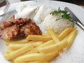 Delicious chicken shish kebab served with rice, fries and yoghurt in a restaurant Royalty Free Stock Photo