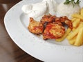 Delicious chicken shish kebab served with rice, fries and yogurt in a restaurant Royalty Free Stock Photo