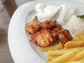 Delicious chicken shish kebab served with rice, fries and yogurt in a restaurant Royalty Free Stock Photo