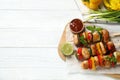 Delicious chicken shish kebabs with vegetables and ketchup on white wooden table, flat lay. Space for text Royalty Free Stock Photo