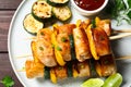 Delicious chicken shish kebabs with vegetables and sauce on wooden table, top view Royalty Free Stock Photo