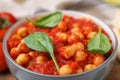 Delicious chickpea curry with basil in bowl, closeup