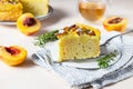 Delicious chiffon cake with custard cream and nectarines with herbal tea and thyme on light concrete background Royalty Free Stock Photo