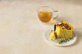 Delicious chiffon cake with custard cream and nectarines with herbal tea and thyme on light concrete background Royalty Free Stock Photo