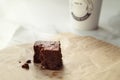 Delicious chocolate brownie with take away coffee in background Royalty Free Stock Photo
