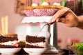 Delicious chocolate cake pieces with cream filling sitting on small plates, hand holding fork grabbing piece, pastry Royalty Free Stock Photo