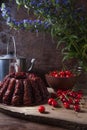 Delicious chocolate cake with sweet cherry, vintage kettle and bouquet of blue flowers on dark wooden background Royalty Free Stock Photo