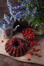 Delicious chocolate cake with sweet cherry, vintage kettle and bouquet of blue flowers on dark wooden background Royalty Free Stock Photo