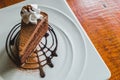 Delicious chocolate cake with wipcream on plate on wooden table. Royalty Free Stock Photo