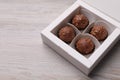 Delicious chocolate candies in box on white wooden table, space for text Royalty Free Stock Photo