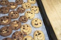 Delicious Chocolate Chip Cookies on baking tray and on wooden table, Top view Royalty Free Stock Photo