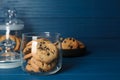 Delicious chocolate chip cookies in glass jar on blue wooden table, space for text Royalty Free Stock Photo