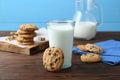 Delicious chocolate chip cookies and glass of milk on wooden table Royalty Free Stock Photo